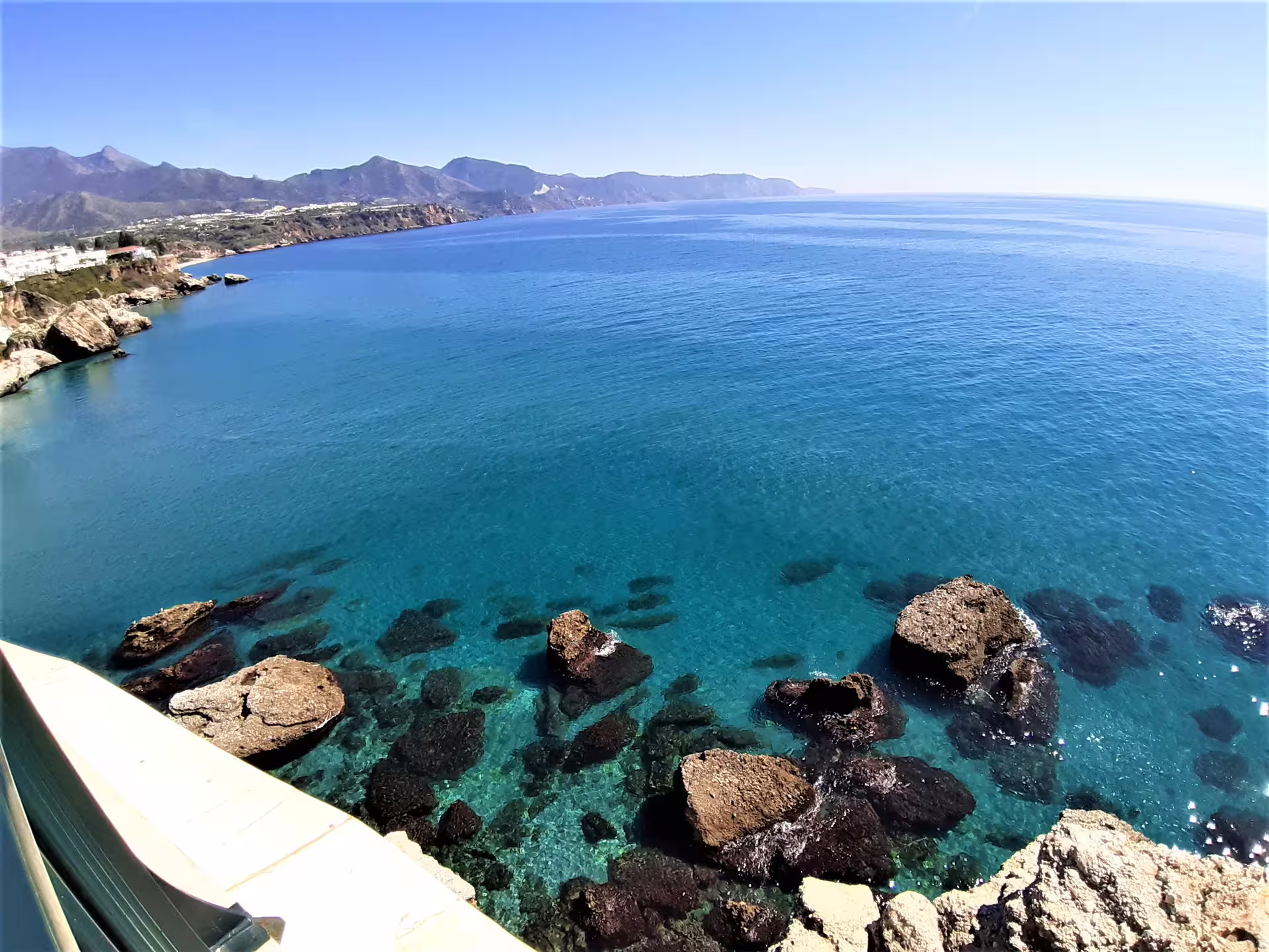 Panoramic Nerja coastline with clear blue water and sea rocks, highlight of a private trip from Malaga