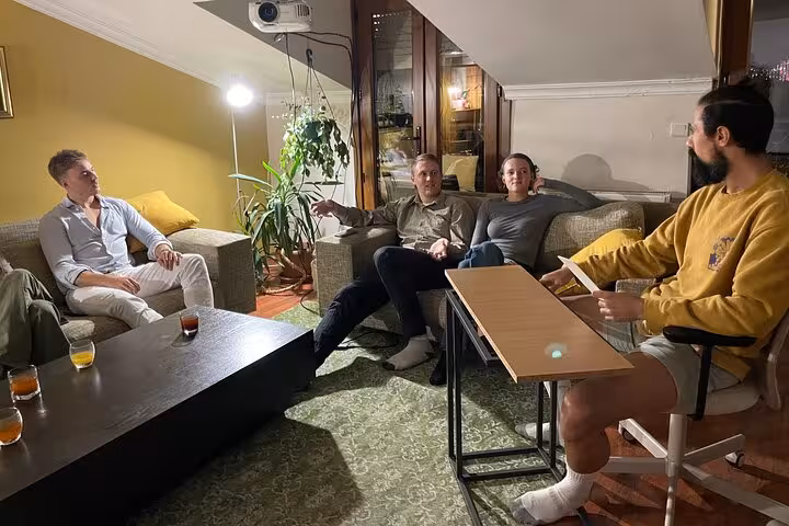 Host leading a networking Turkish tea tasting in Istanbul, guests sipping çay and socializing in a home setting