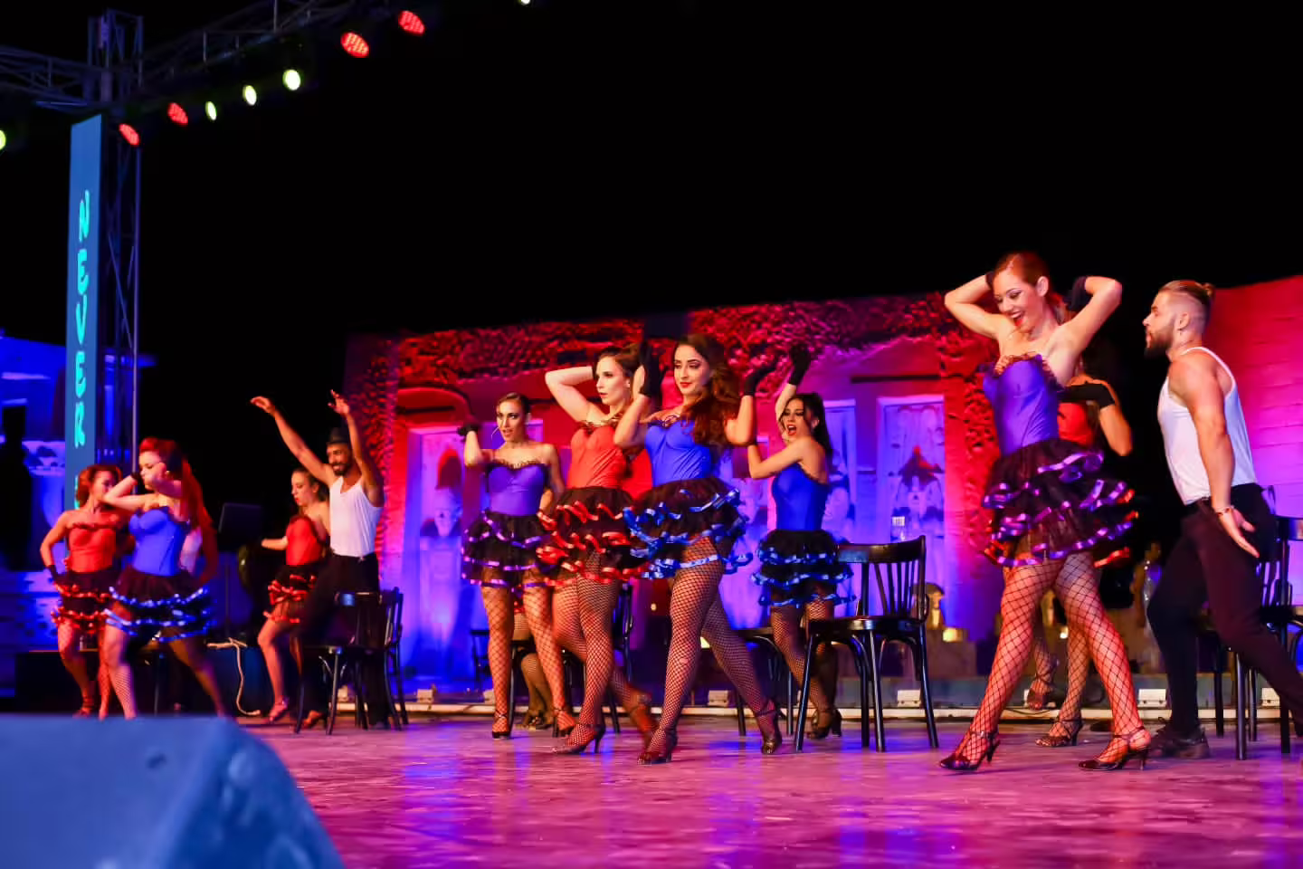 Neverland Musical and Cabaret Show chorus line dancers in colorful costumes performing chair cabaret routine