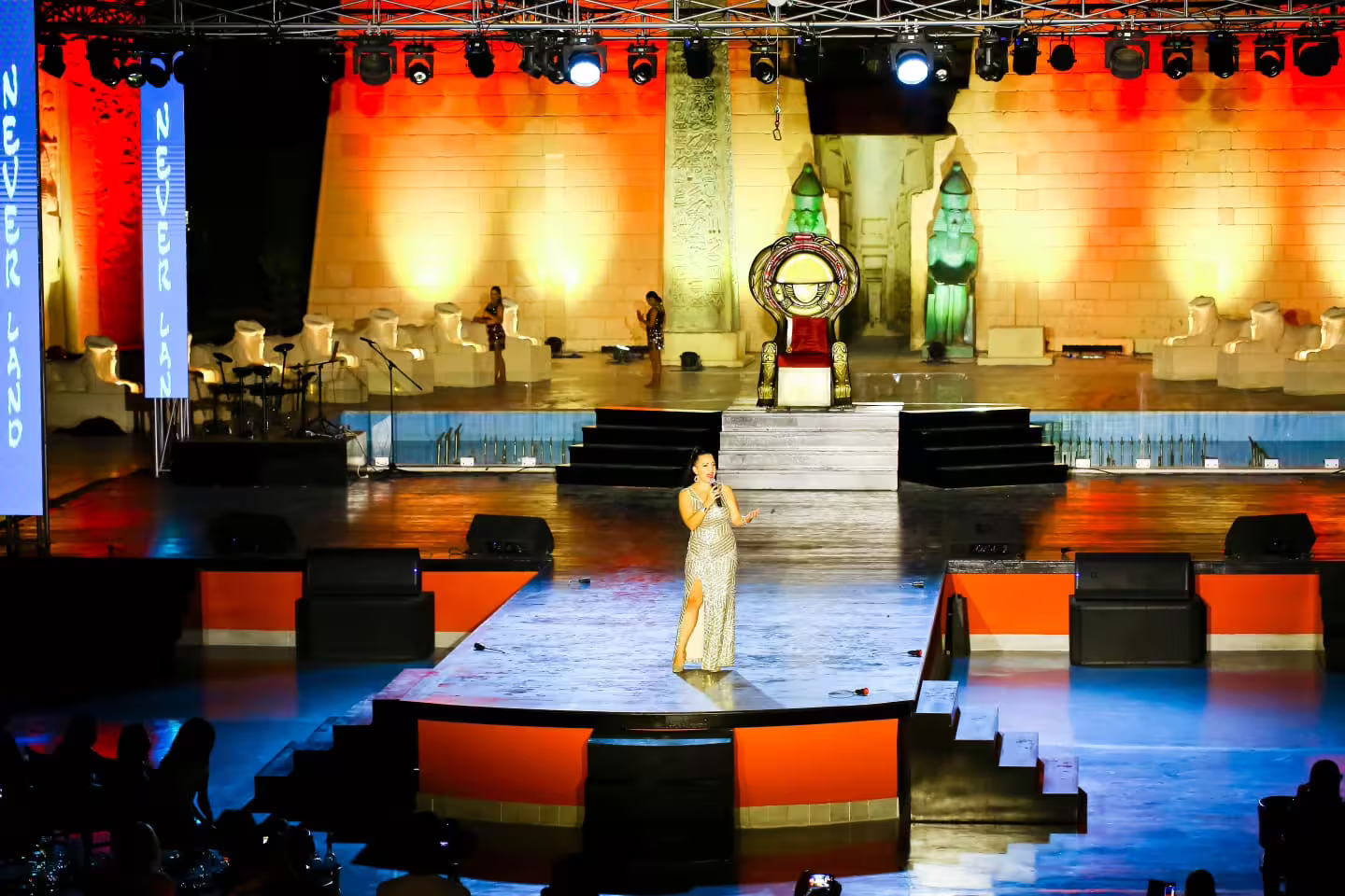 Singer performing on the Neverland musical cabaret stage with Egyptian-themed set and dramatic lighting