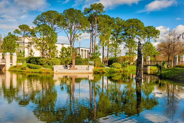 Tranquil lagoon with tree reflections and sculptures in New Orleans City Park