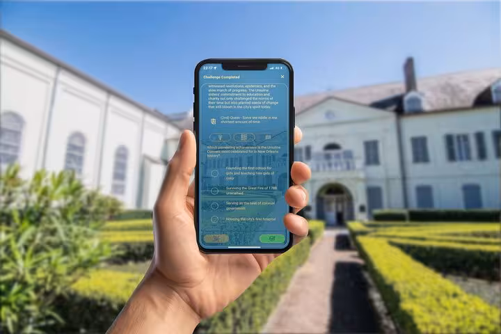 Hand holding smartphone with self-guided walking tour app game in New Orleans French Quarter