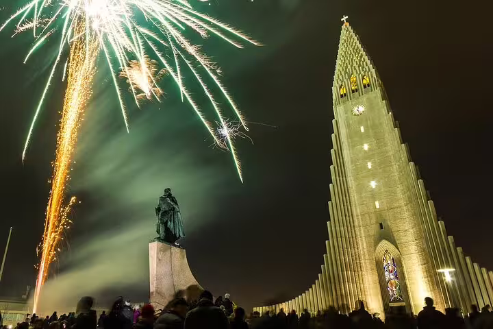 Fireworks exploding over Hallgrímskirkja church and Leif Erikson statue during New Year's Eve celebration in Reykjavik