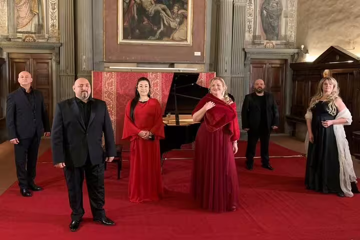 Ensemble cast posed by grand piano for New Year's Eve Opera Gala 31 December, festive classical concert night
