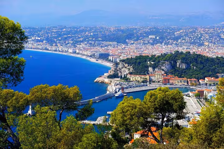 Aerial view of Nice coastline with turquoise Mediterranean Sea, harbor, and city stretching along the French Riviera