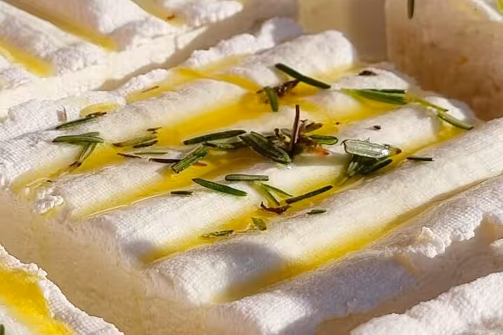 Fresh white cheese scored with olive oil and rosemary herbs on a Nice gourmet tour