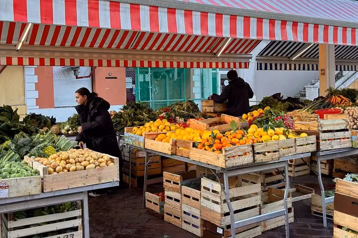 Colorful fresh fruit and vegetable stalls at an outdoor market in Nice, France