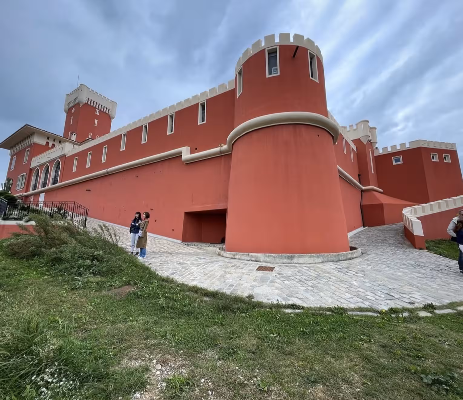 Red castle-like vineyard building with battlements and cylindrical towers near Nice, France