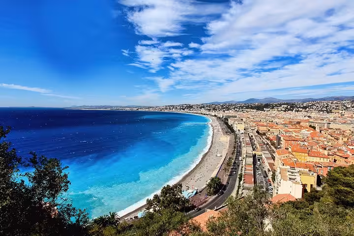 Aerial view of Nice city coastline with turquoise Mediterranean Sea and terracotta rooftops along French Riviera