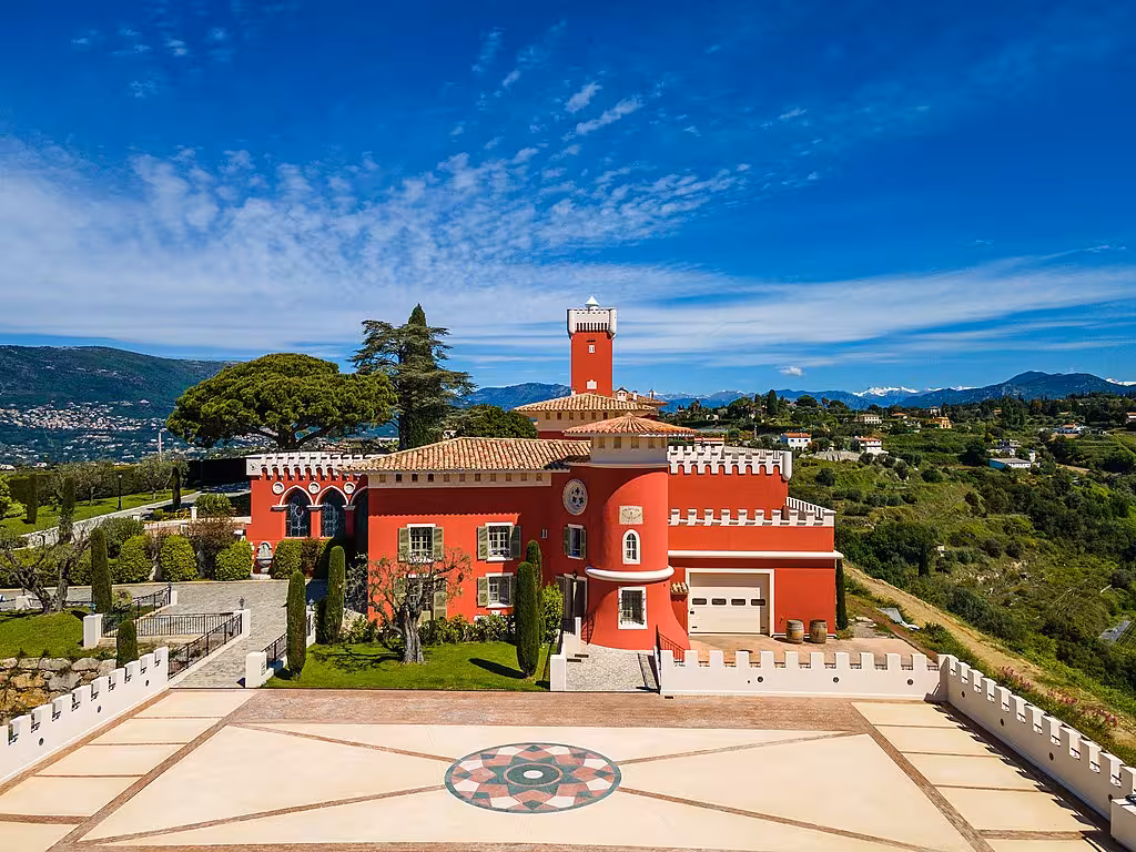 Stunning red castle-like vineyard estate in Nice with panoramic mountain views for private wine tasting tours.