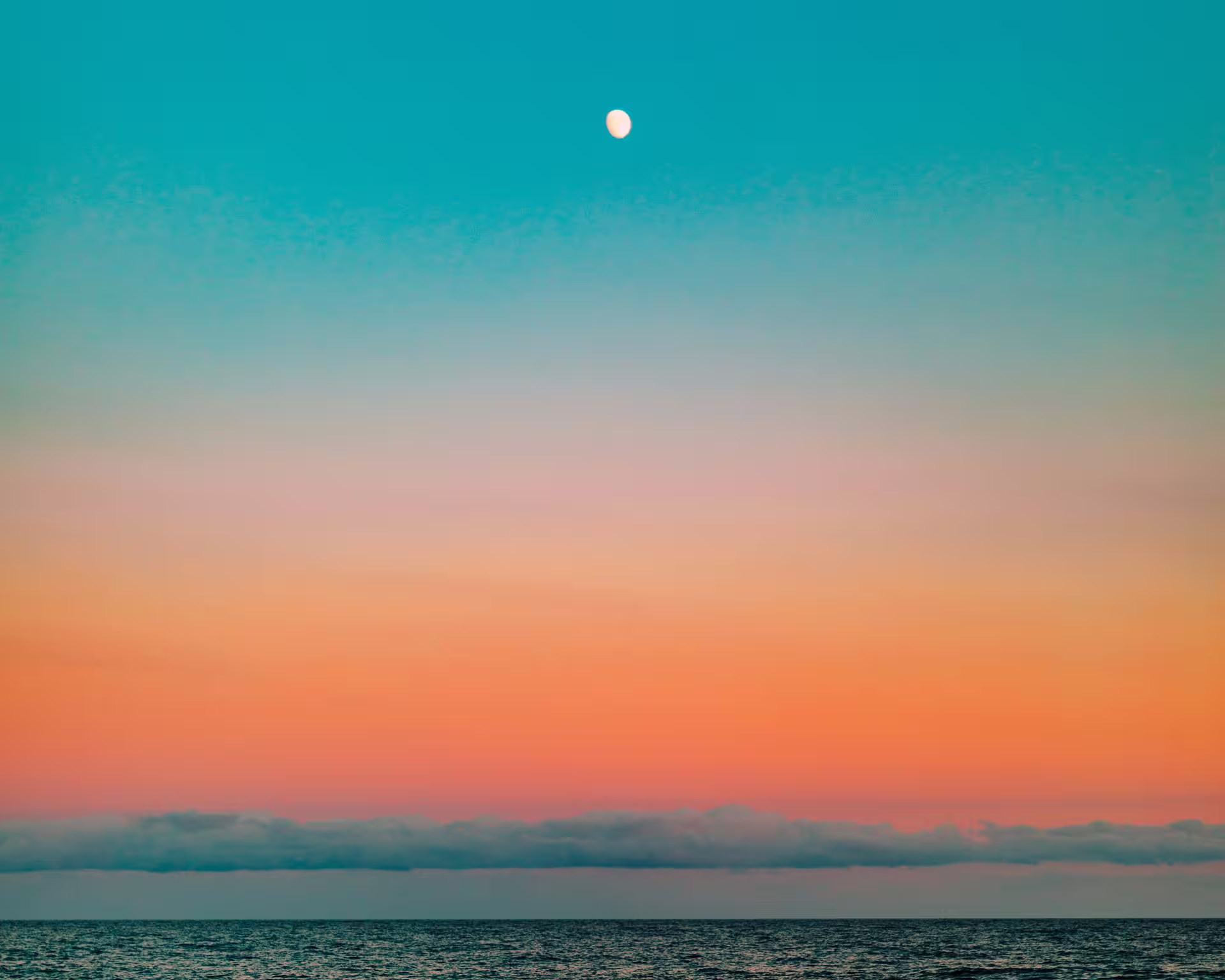 Sky that goes from top to bottom, to the horizon of the sea, cyan, light blue, pink, orange to an intense reddish color.