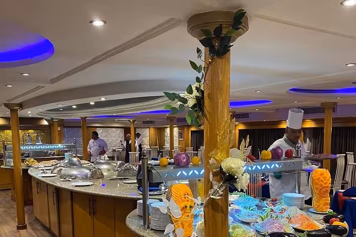 Nile cruise restaurant buffet with chef and carved vegetables, part of 8-day Egypt Cairo Aswan Luxor itinerary