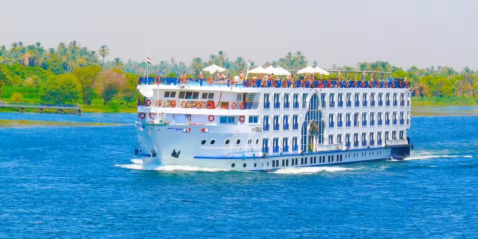 5-star Nile cruise ship sailing past palm-lined banks, luxury Cleopatra’s Egypt Cairo to Alexandria package