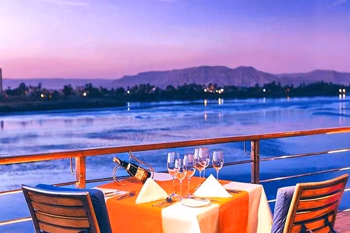 Romantic sunset dinner setup on Nile cruise deck, 5-day private Luxor to Aswan deluxe experience