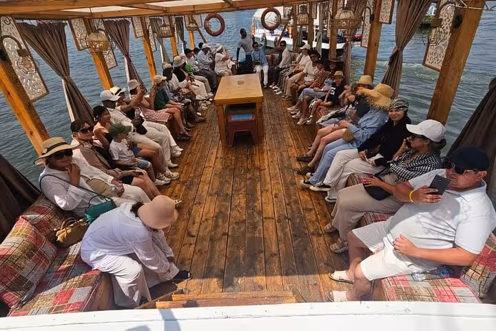 Guests relax on a traditional Nile felucca boat in Cairo, enjoying a scenic sailing tour with pickup