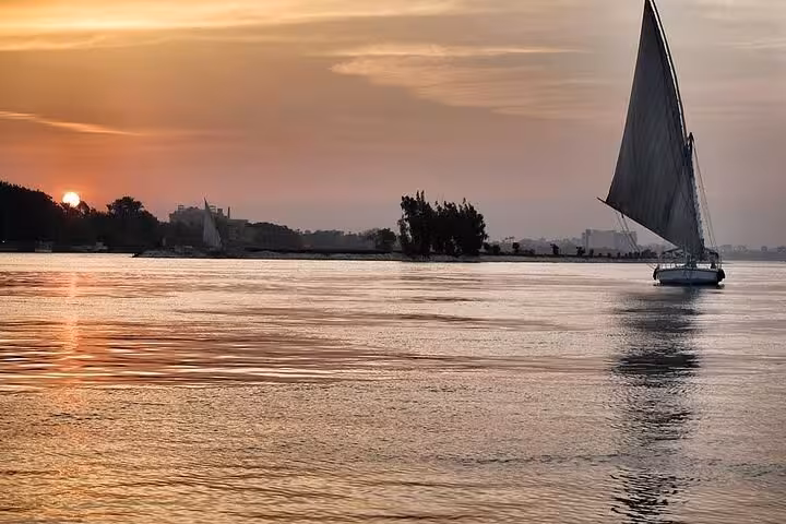 Nile felucca sailing at golden sunset on calm waters, scenic Cairo river cruise and authentic Egyptian felucca ride