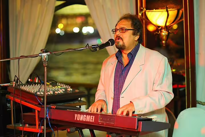 Keyboardist singing live on Nile Maxim dinner cruise in Cairo, evening entertainment with oriental show