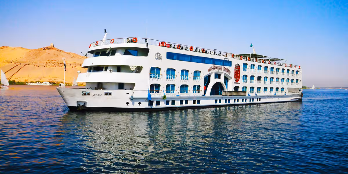 Nile Pearl 5-star Nile cruise ship sailing the Nile River near Aswan, Egypt, with desert hills in background