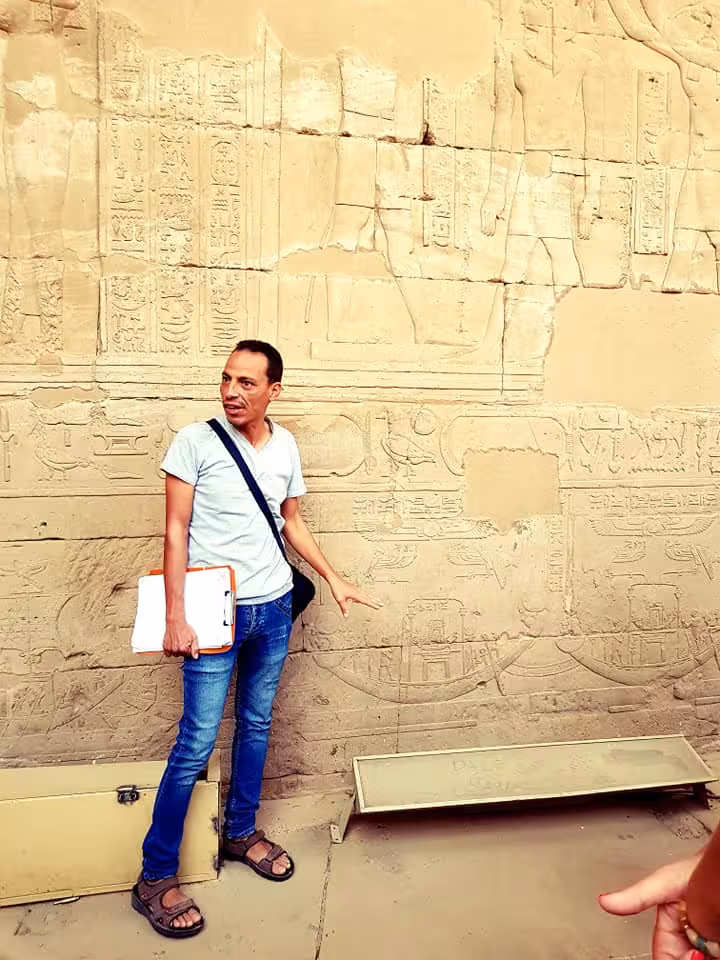 Egyptologist guide explains ancient hieroglyphs at Luxor temple on Nile Pearl 5-star Nile cruise tour