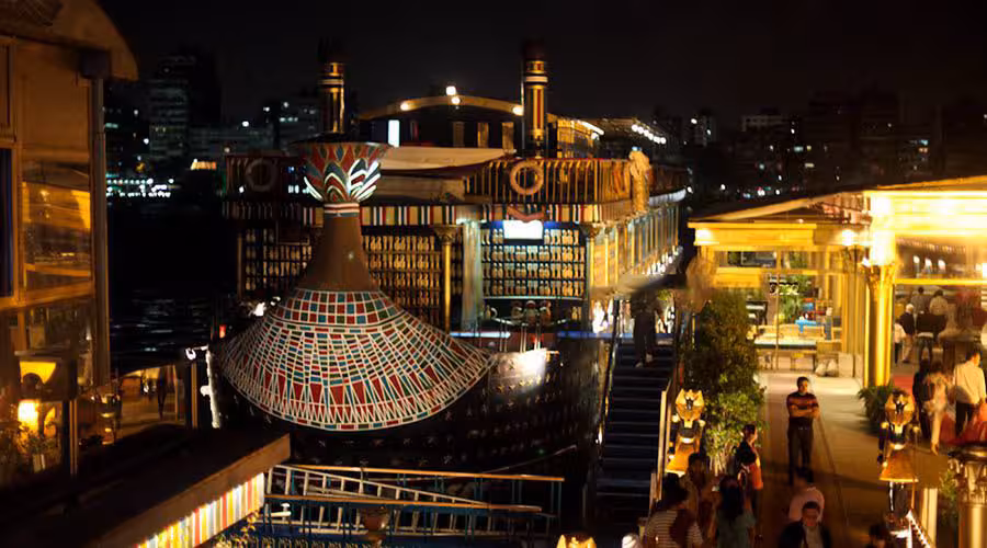 Night view of a pharaonic-style Nile cruise boat docked in Cairo, ideal for Nile Pharaohs Cruising Booking
