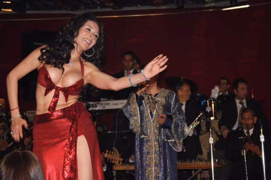 Live belly dance show with musicians during a Nile River night dinner cruise in Cairo, onboard stage performance