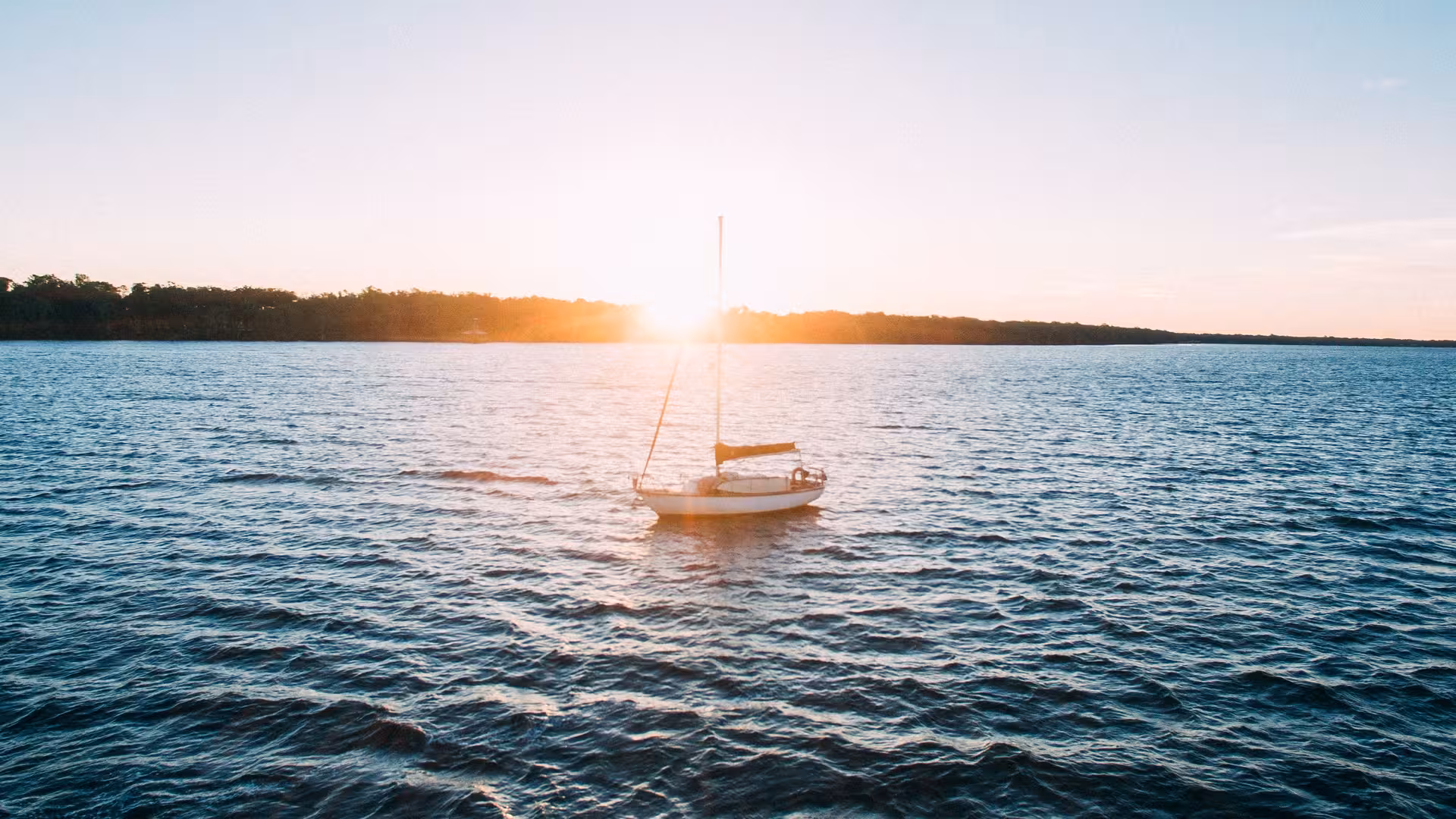 Sunset sailboat on the Nile River, serene waters on an 11-day budget Egypt adventure tour with fees included