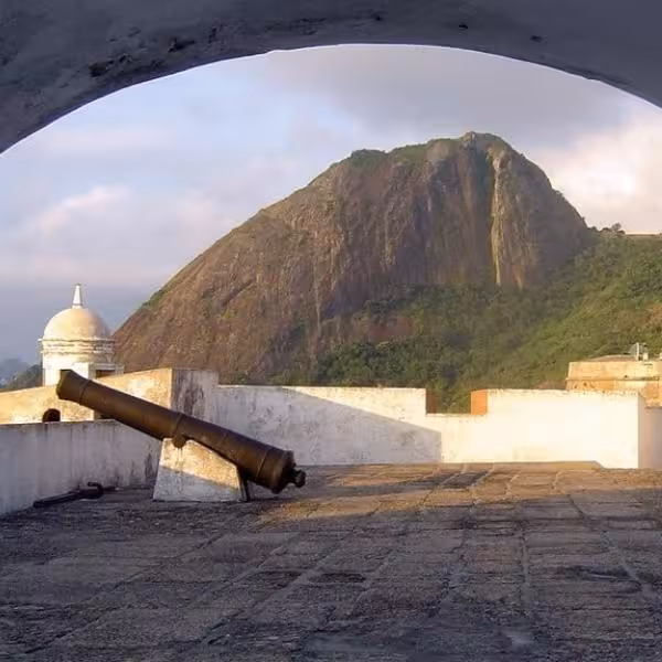View of Niterói's historic fort with cannon and majestic Sugarloaf Mountain in the background, ideal for private tours.
