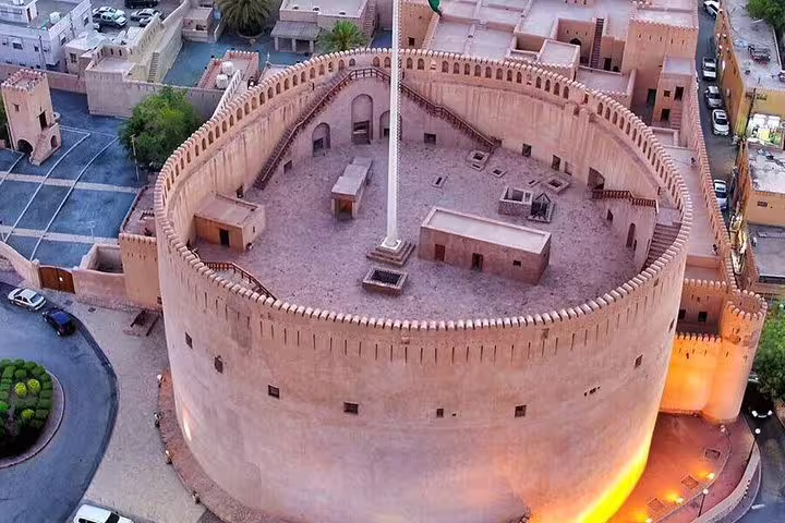 Aerial view of historic Nizwa Fort at sunset, a key highlight on the Muscat full day private tour to Nizwa.