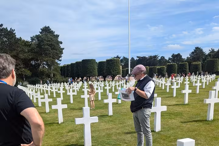 Visitors among white crosses at Normandy American Cemetery on a D-Day Beaches private tour