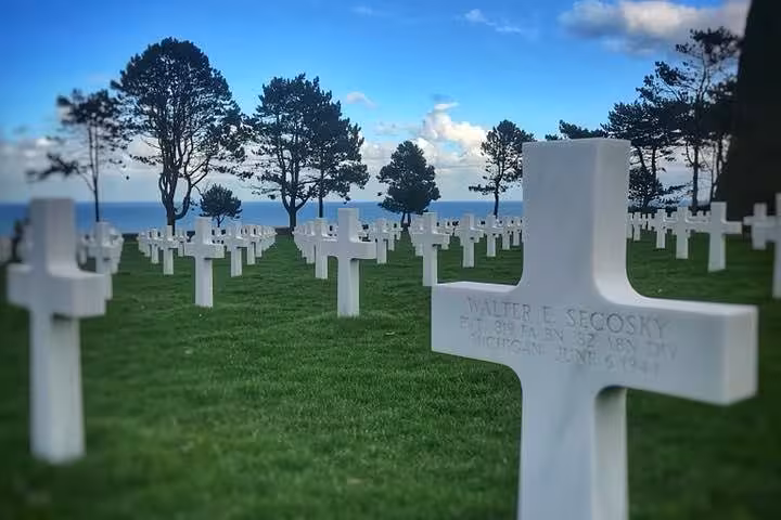 Rows of white crosses at Normandy American Cemetery overlooking D-Day beaches, with Walter E. Secosky grave in foreground