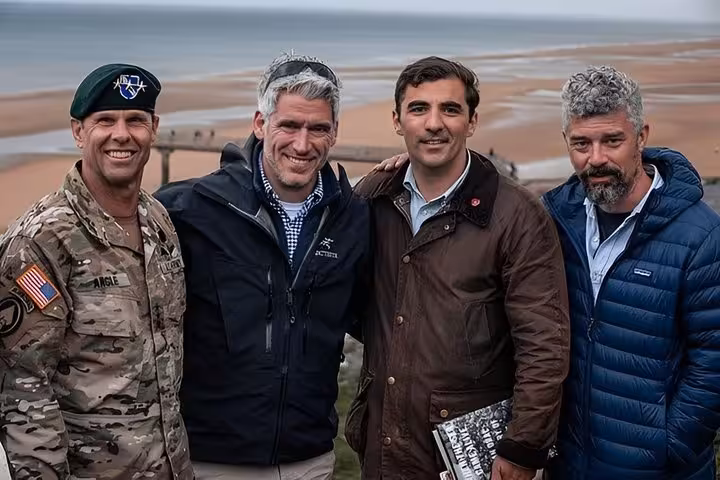 US Army soldier and three men posing together at Normandy D-Day beach overlook