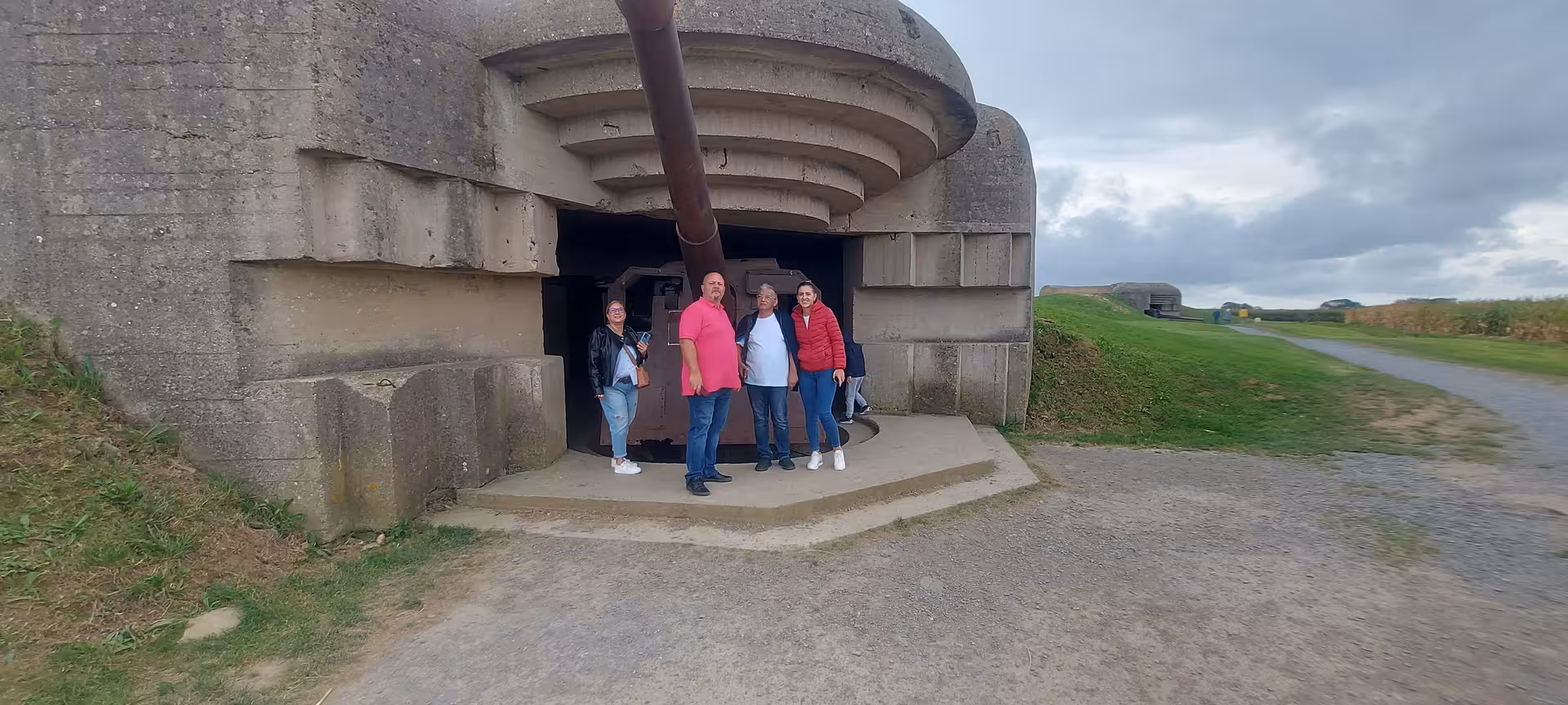 Small-group Normandy D-Day tour guests at Longues-sur-Mer German gun bunker, private luxury minivan day trip