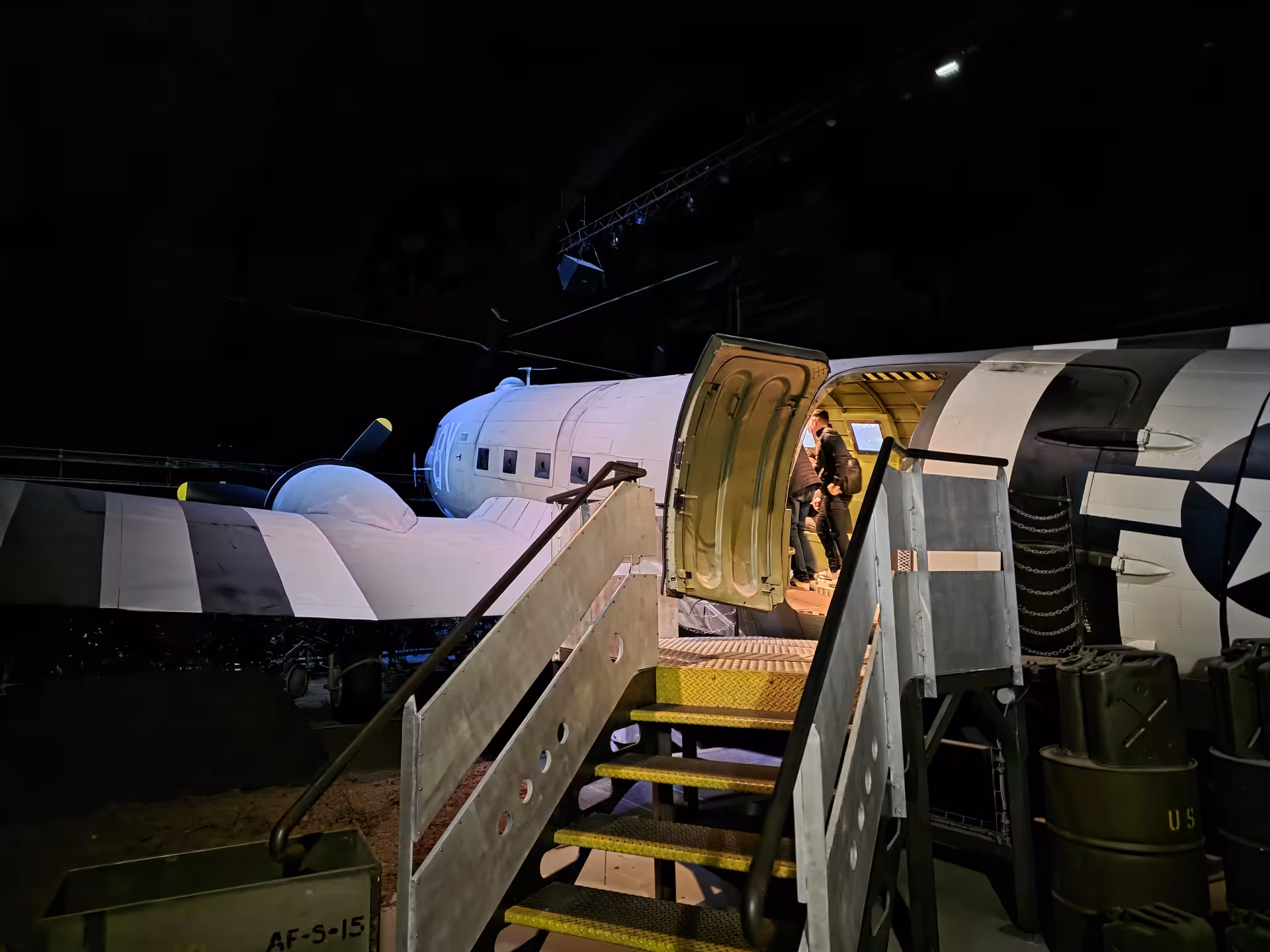 Visitors boarding a WWII C-47 aircraft exhibit at a Normandy D-Day museum on a private guided tour