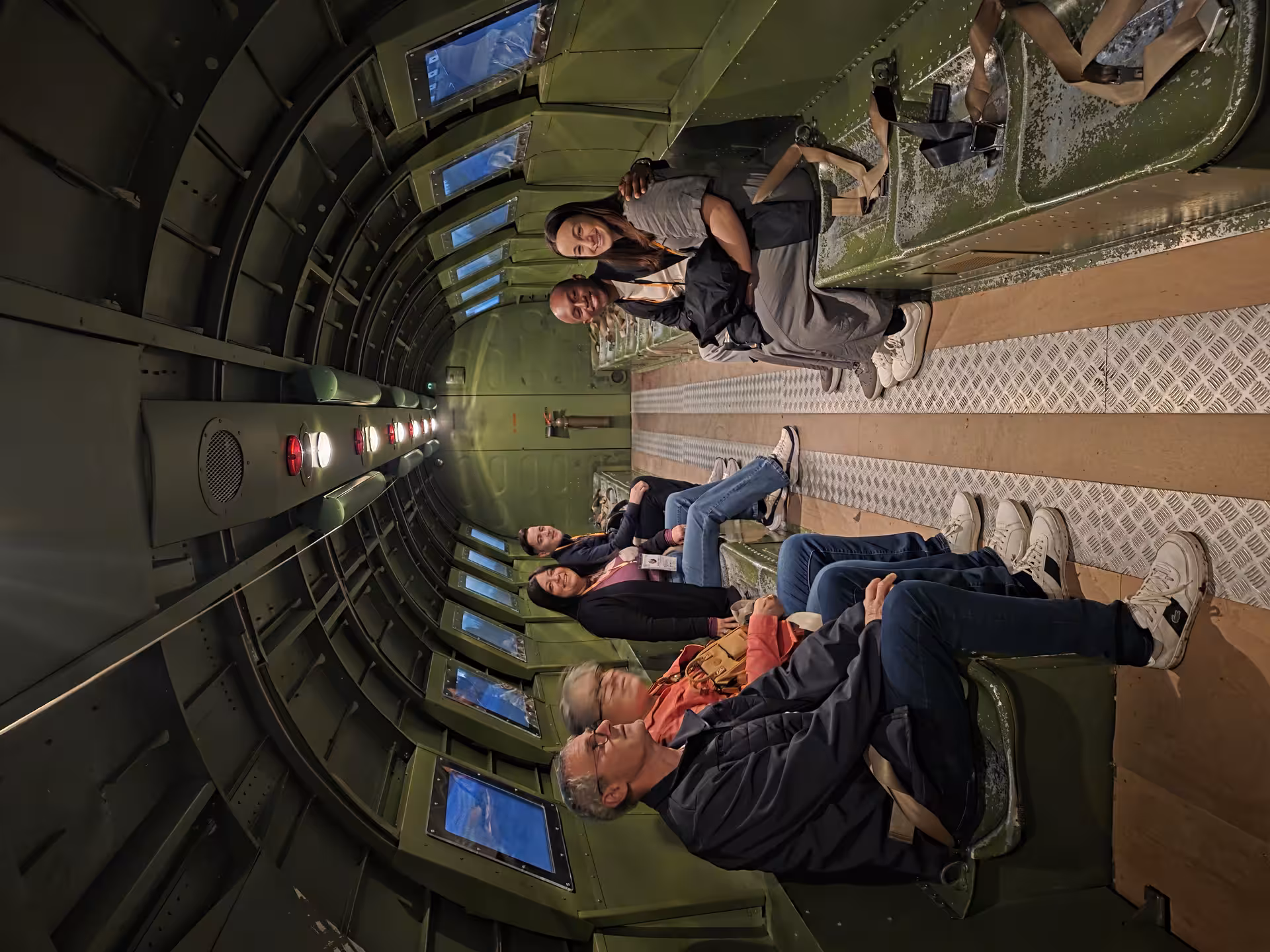 Tour group explores the interior of a WWII military aircraft exhibit on a private guided Normandy D-Day sites tour.