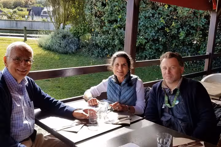Three people enjoying lunch together on a restaurant terrace in Normandy, France