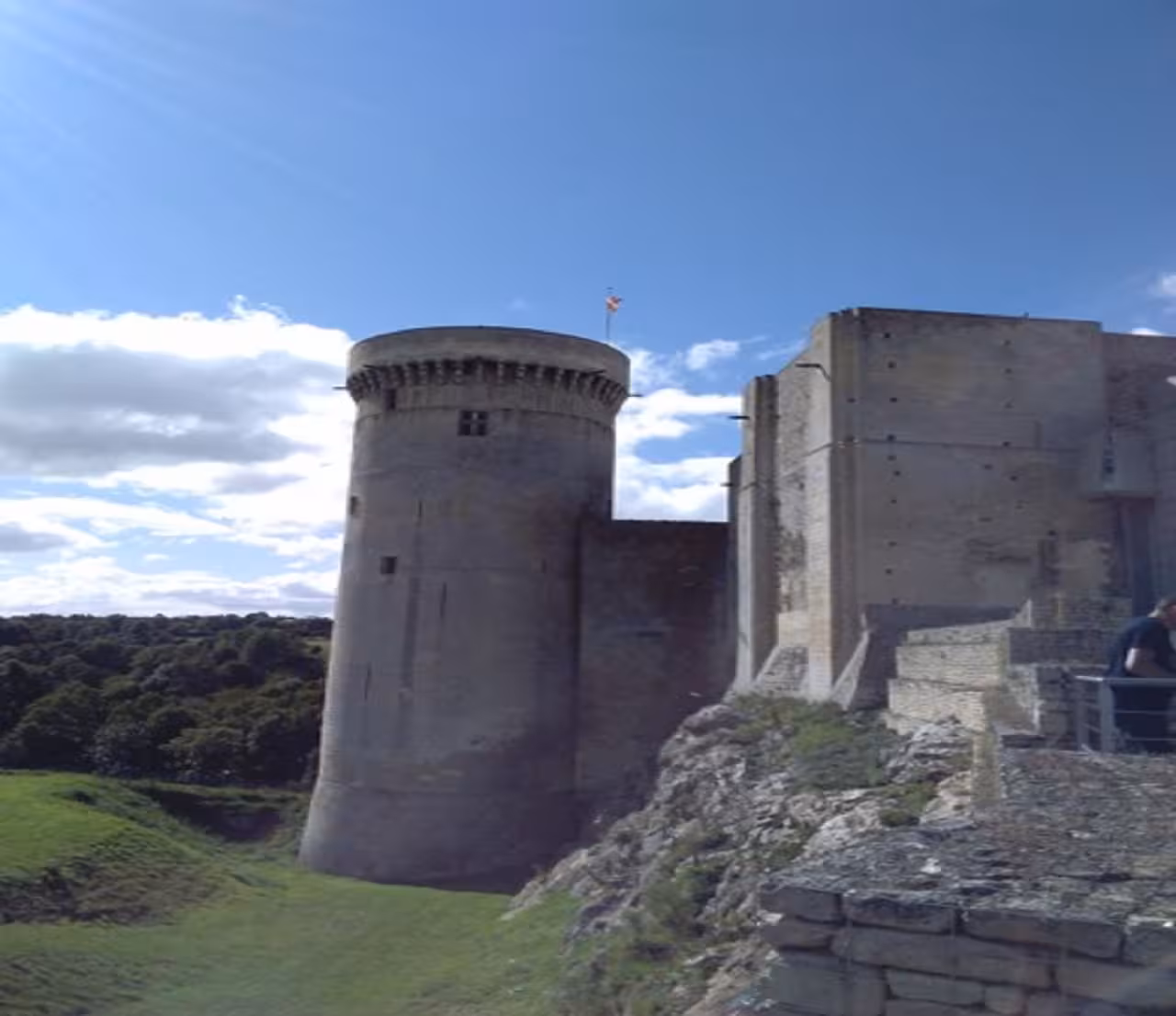 Medieval round tower and stone keep of a Normandy castle under blue sky
