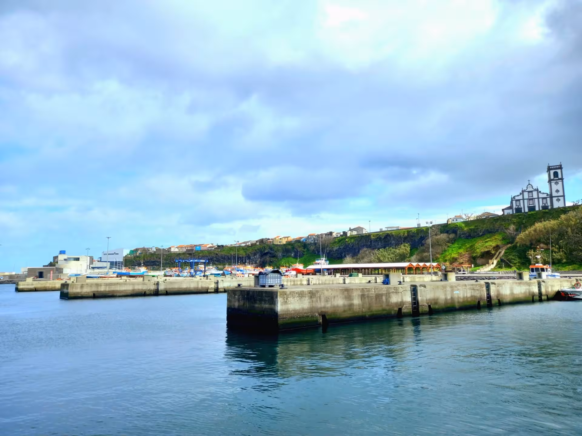 North Coast harbor departure point for whale watching expedition, calm marina waters and coastal village skyline