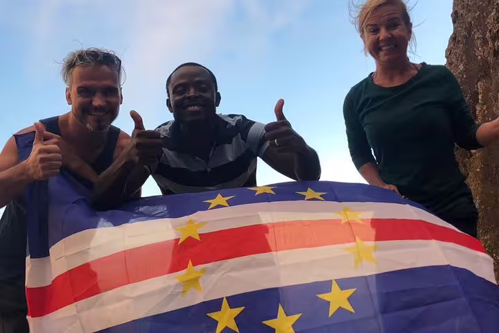Tourists holding a flag, showing excitement on the Northeast Coast and Lagoa Natural Pool tour.