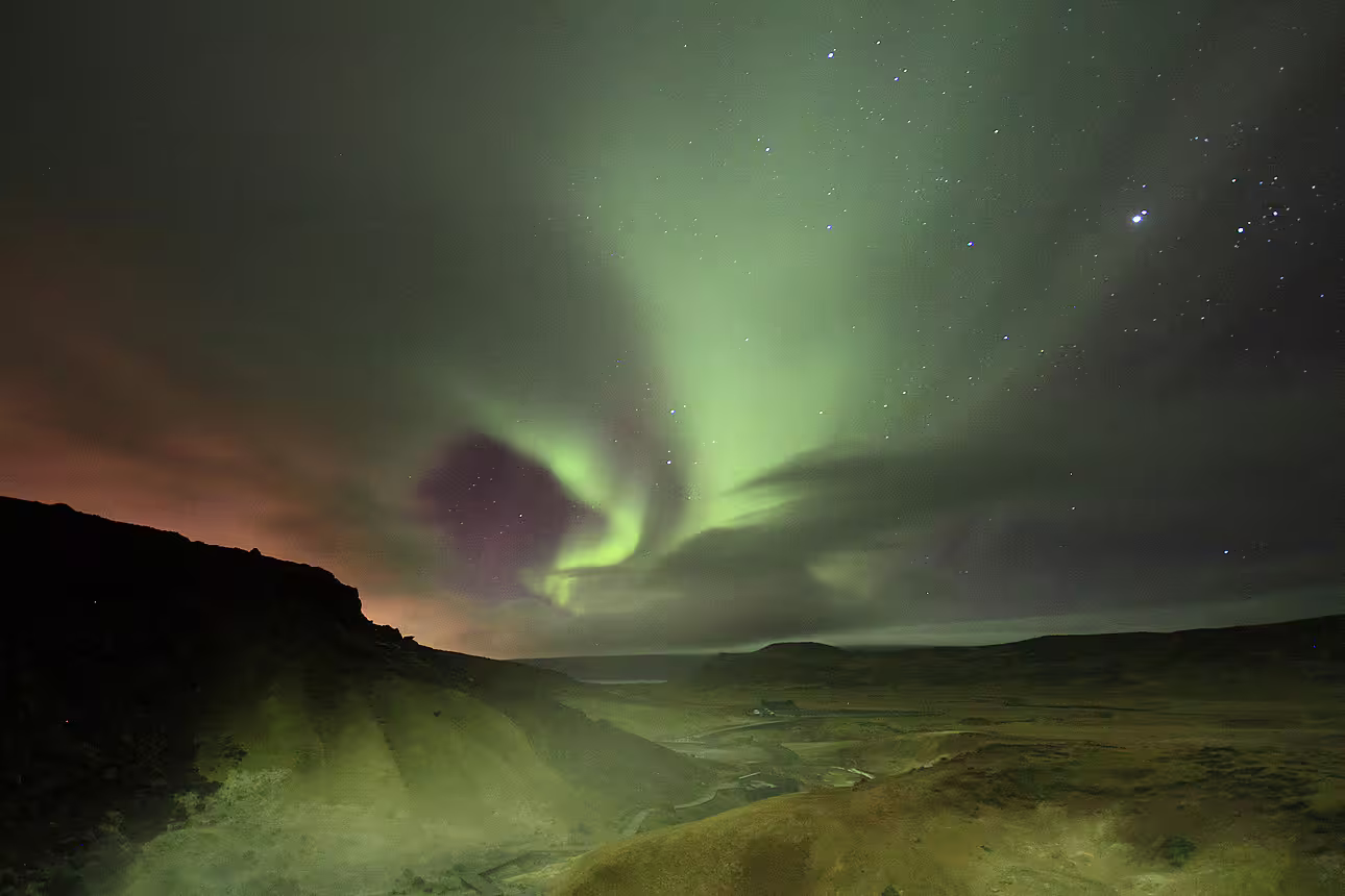 Aurora borealis northern lights swirling over Icelandic highlands valley near Reykjavik at night