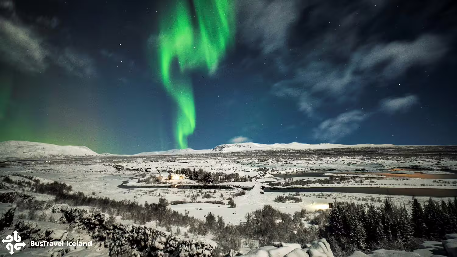 Northern lights dancing over snowy Þingvellir landscape near Reykjavik, Iceland on a clear winter night