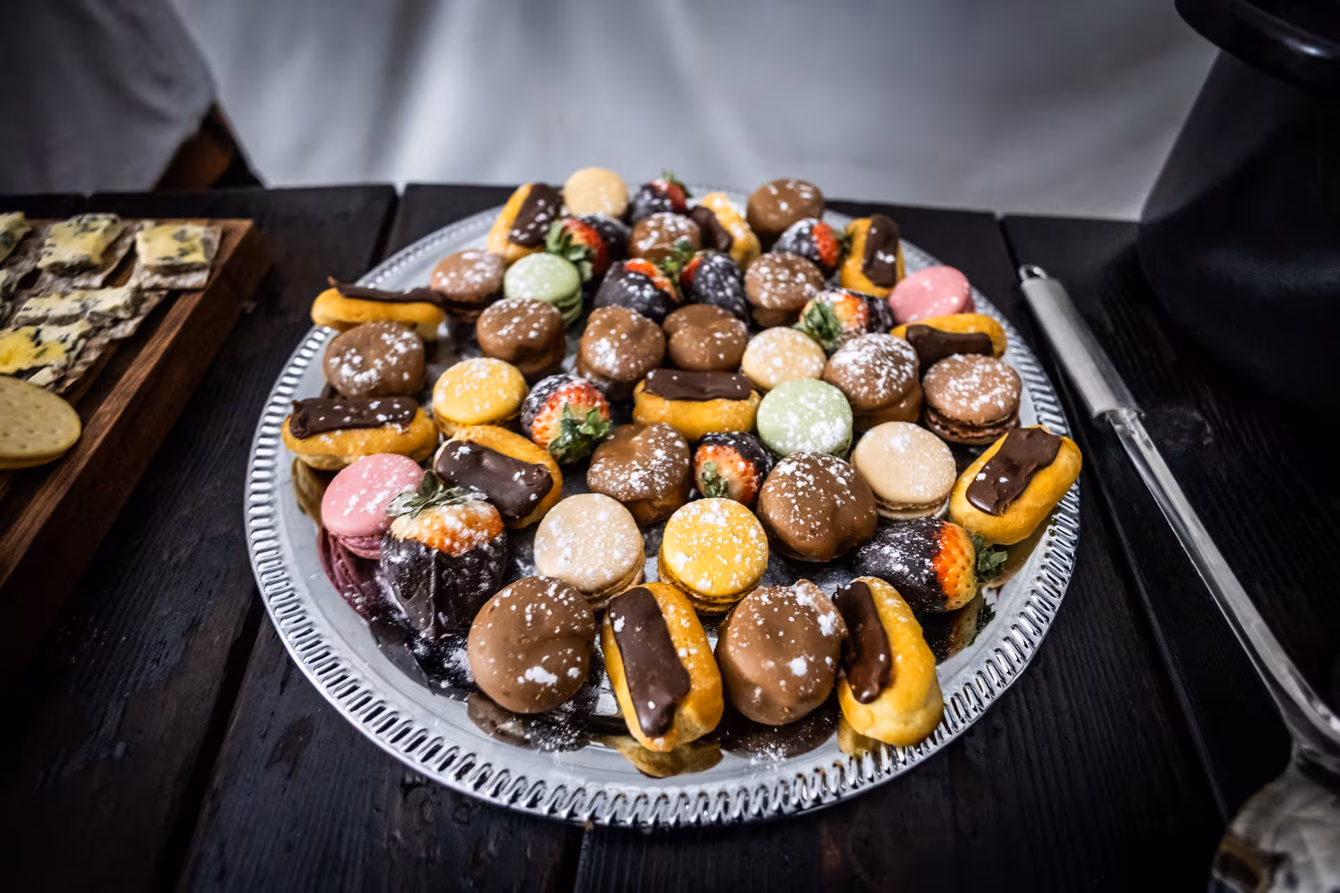 Elegant dessert platter with colorful macarons chocolate eclairs and strawberries served at northern lights dinner Iceland
