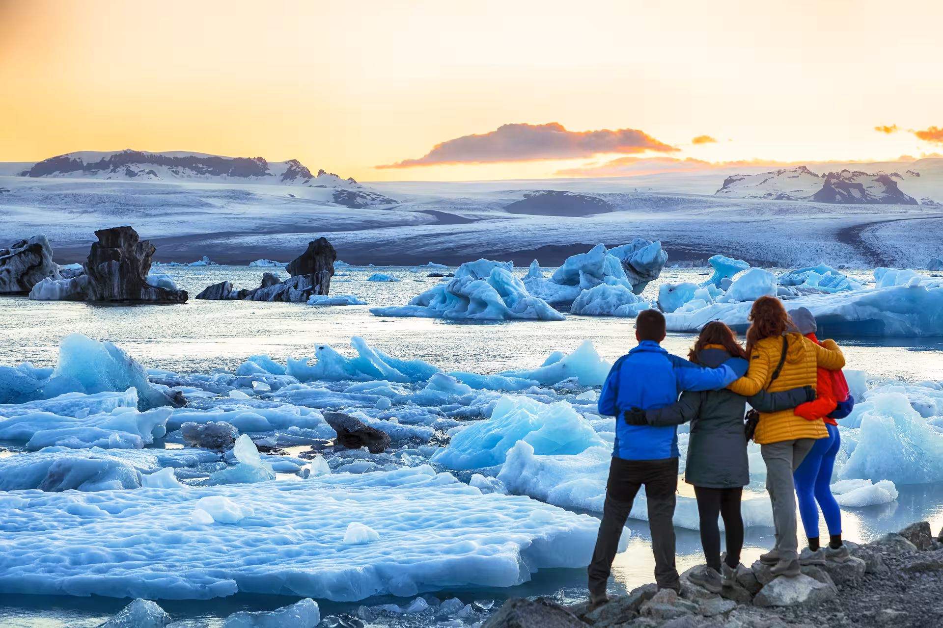 Group admiring breathtaking glacier lagoon at sunset on 5-Day Northern Lights Hunt & Glacier Lagoon Tour.
