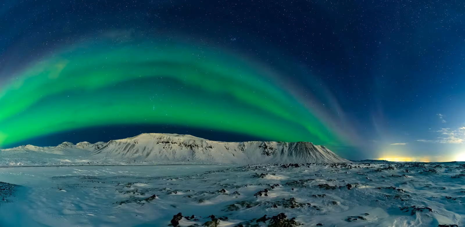 Stunning Northern Lights over snowy Icelandic landscape, a highlight of the 4-day Iceland stopover tour.