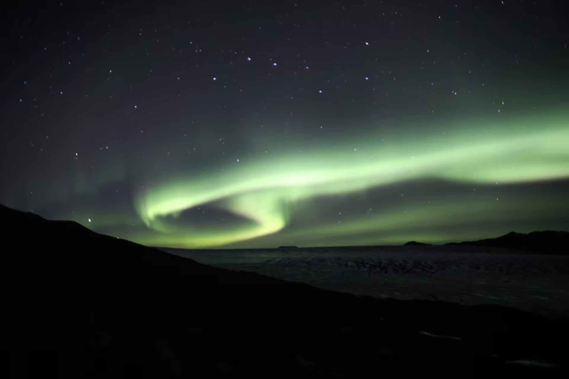 Northern lights aurora borealis swirling over Langjokull glacier Iceland at night