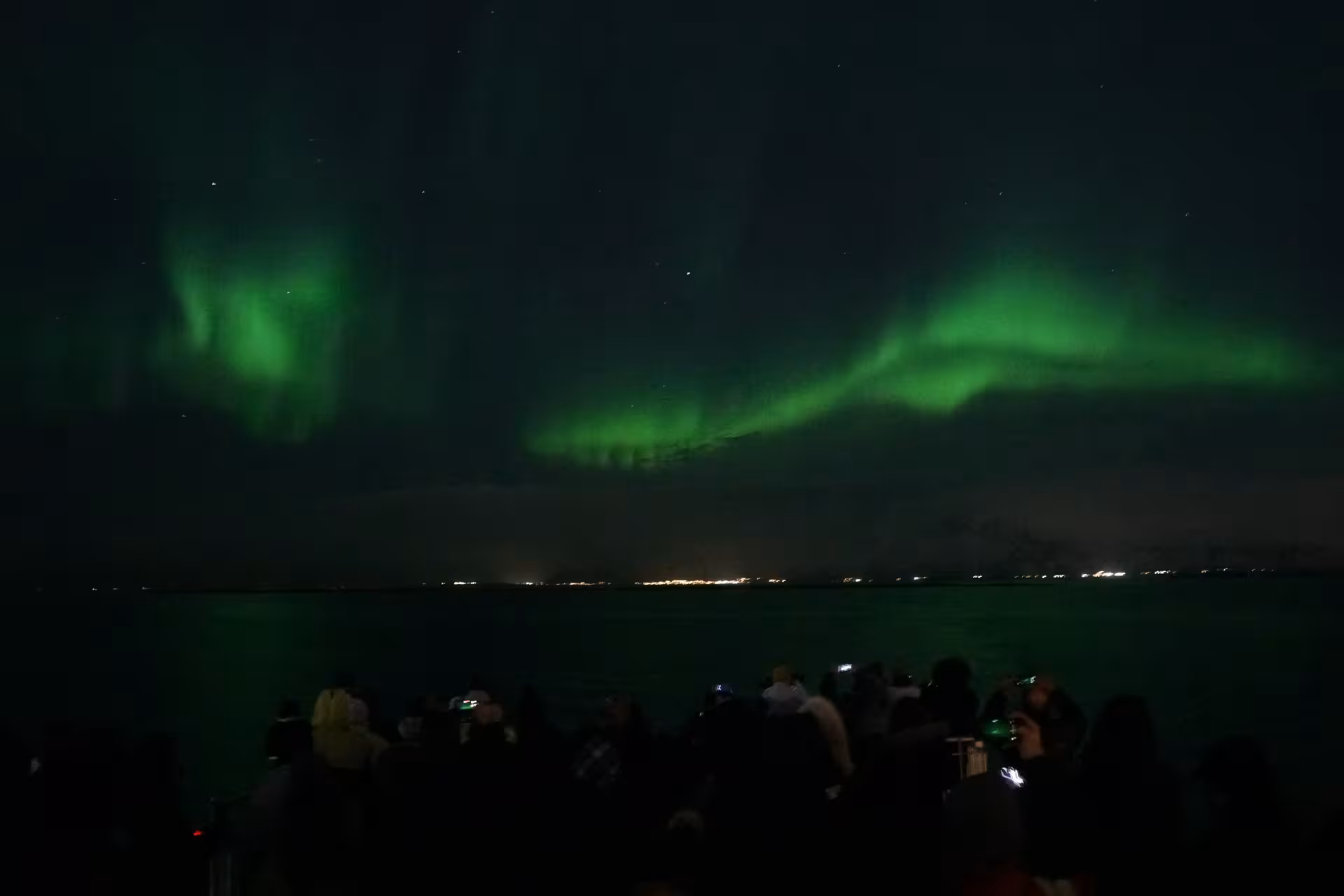 Northern Lights visible above the ocean during a Reykjavík boat trip