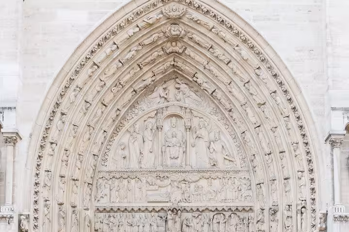 Close-up of Notre Dame carved stone tympanum, a kid-friendly outside guided tour highlight in Paris