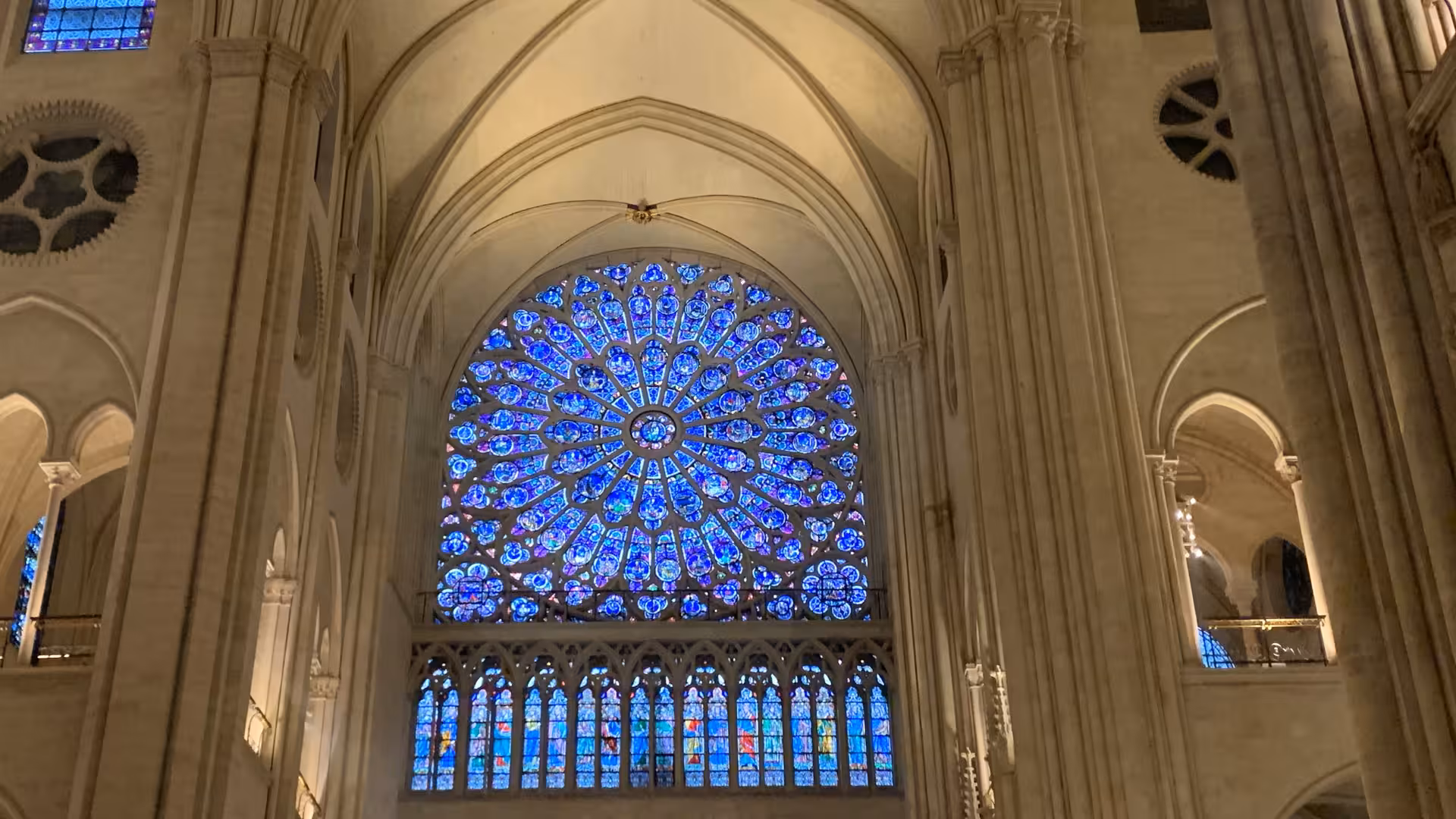 Gothic rose window with blue stained glass inside Notre-Dame Cathedral Paris