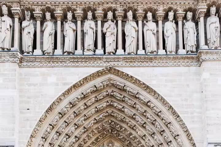 Notre-Dame facade statues above the Gothic arch, a highlight of the outdoor guided tour for kids in Paris
