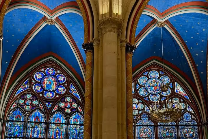 Notre Dame interior guided tour view of Gothic arches and vibrant stained glass windows in Paris