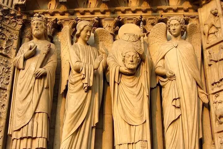 Intricate Gothic stone sculptures of saints and angels on Notre Dame Cathedral Paris portal walking tour